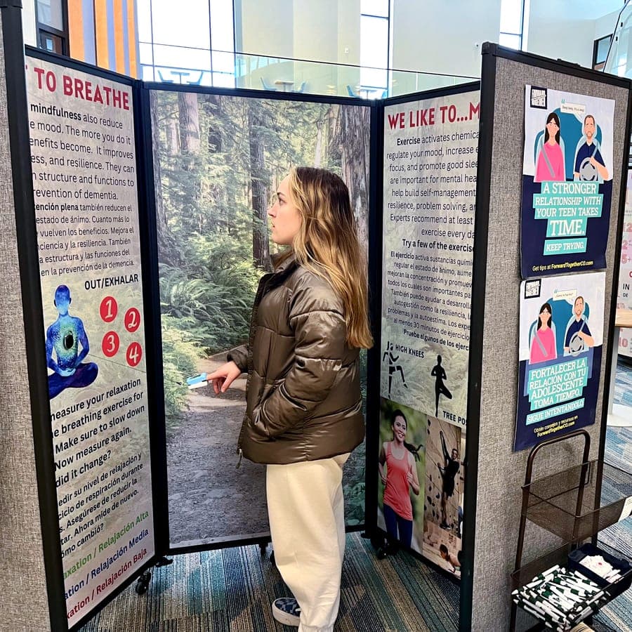 A visitor tries a pulse oximeter at the bilingual Be Mindful, It Matters mental health exhibit