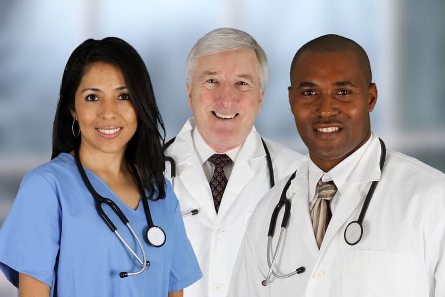 A nurse and two doctors smiling together